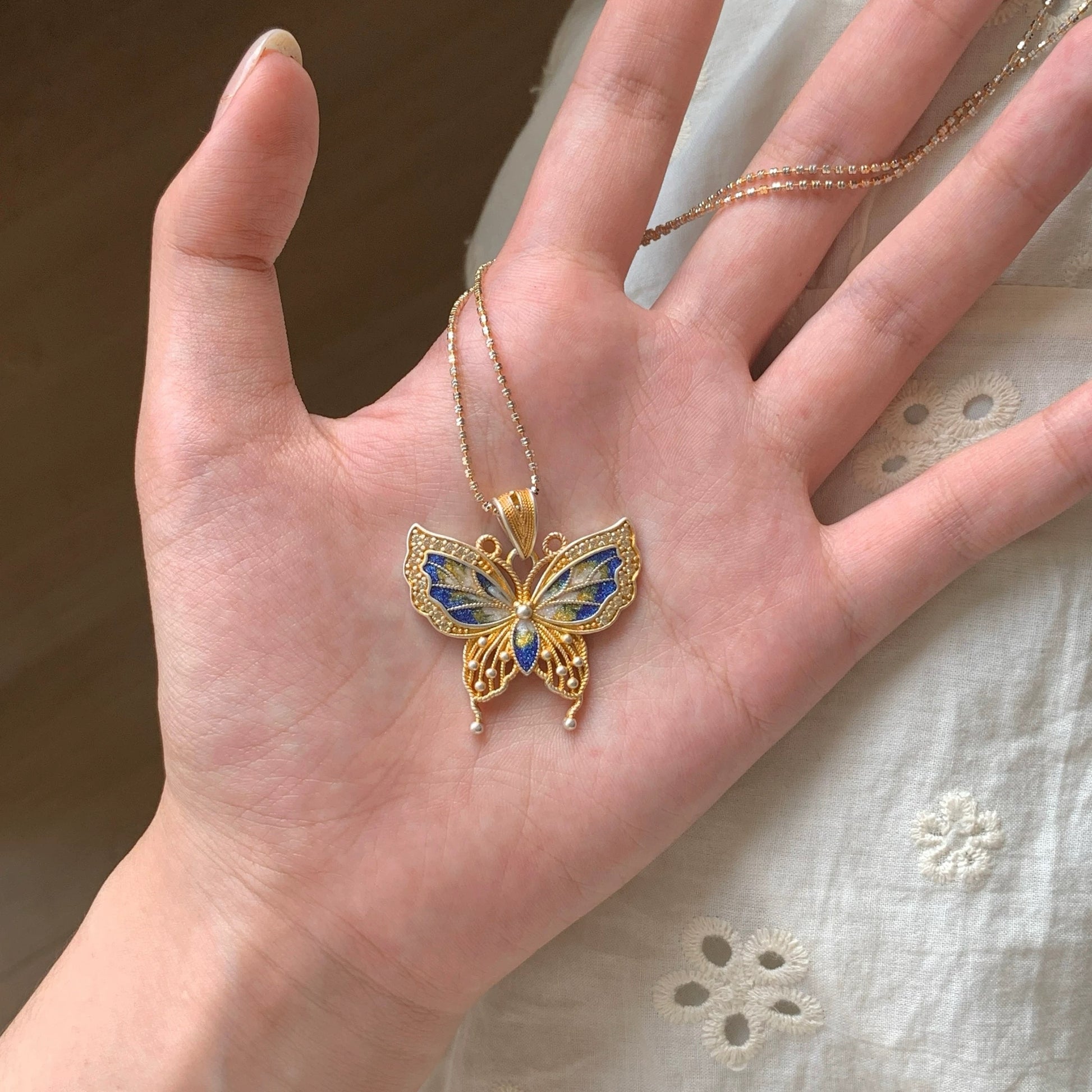 Butterfly pendant combining hollow silverwork and colorful enamel — a graceful Chinese enamel jewelry piece symbolizing transformation.
