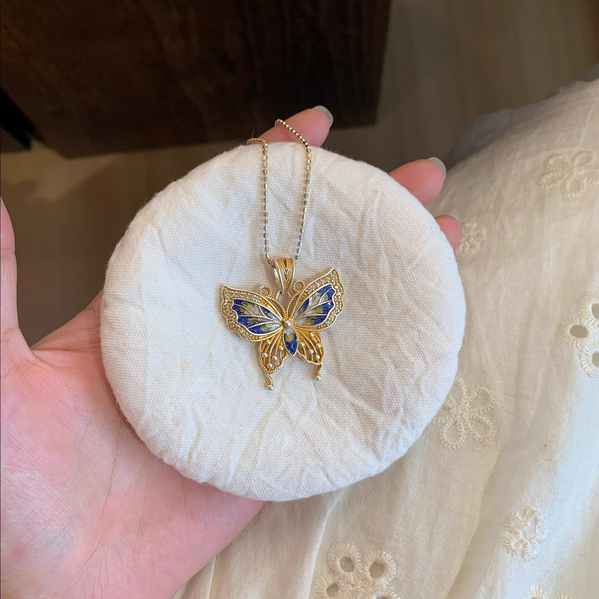 Butterfly pendant combining hollow silverwork and colorful enamel — a graceful Chinese enamel jewelry piece symbolizing transformation.
